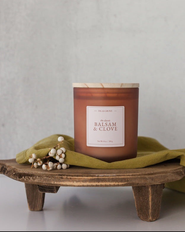 Balsam & Clove candle in brown glass jar with white berries evoking fresh mountain air and warm spice – Fig & Grove