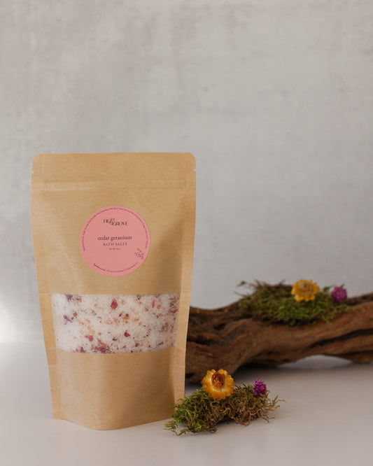 Cedar Geranium essential oil bath salts in a Kraft resealable pouch with a pink label on a neutral background - Fig & Grove