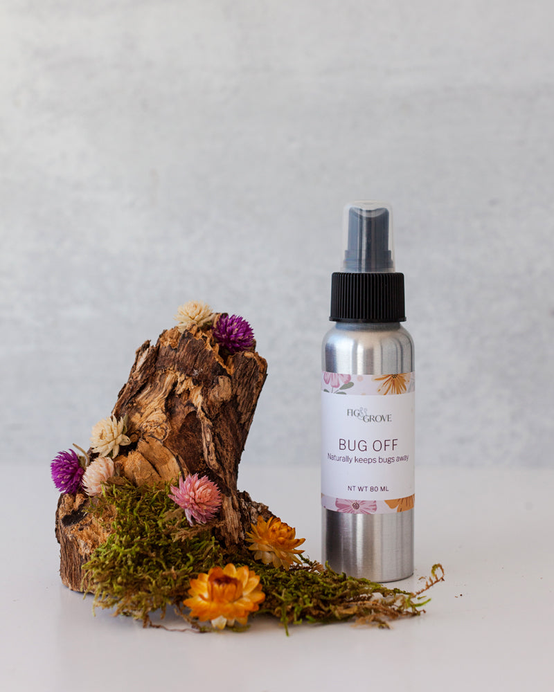 Fig & Grove Bug Off natural bug spray lotion in 80ml aluminum bottle styled with colorful dried flowers and moss — all-natural handmade bug spray made in Copperopolis California with coconut oil and essential oils